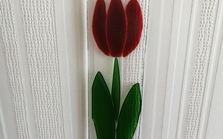 Punainen tulppaani lasikukka ikkunaan