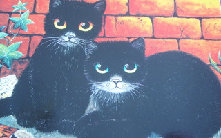 Anna Hollerer mustat kissat tiiliseinän vierellä