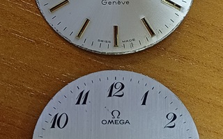 Kaksi miesten Omega kellotaulua.