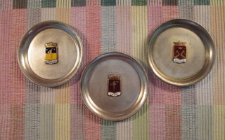 Karjala, Lappi ja Satakunta vaakunat pienissä lautasissa.