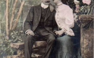 RAKKAUS / Tyttö nojaa miehen olkapäähän puutarhassa. 1900-l.