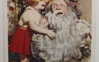 Lapsi silittää Joulupukin pitkää partaa, p. 1956