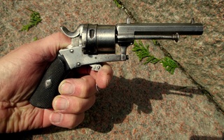 Revolveri keskisytytteinen lupavapaa kudestilaukeava ase.