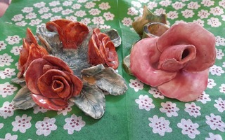 Ruusuja ja rosoa keraamisissa kynttilänjaloissa