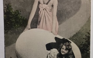 Tyttö ja karitsa ryömivät jättimäisestä Pääsiäismunasta 1915