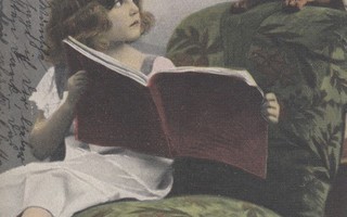 Tyttö näyttää kirjaa koiralle