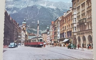 Innsbruck;pääkatua, raitiovaunu, liikkeitä, vuoret taustalla