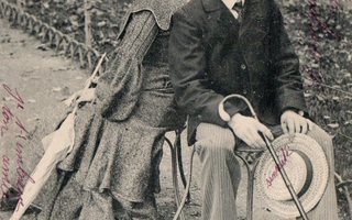 Vanha postikortti- nainen ja mies puistossa