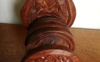 Puinen kuvioitu teline jossa 6 lasinalustaa