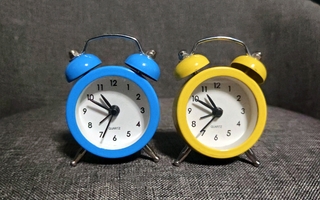 Kaksi minikokoista herätyskelloa (keltainen ja sininen)