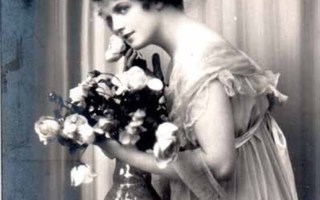 NAINEN / Kaunis tyttö järjestelee kukkia maljakossa. 1910-l.