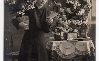 KONFIRMAATIO / Ripiltä päässyt tyttö ja kukkapöytä. 1910-l.